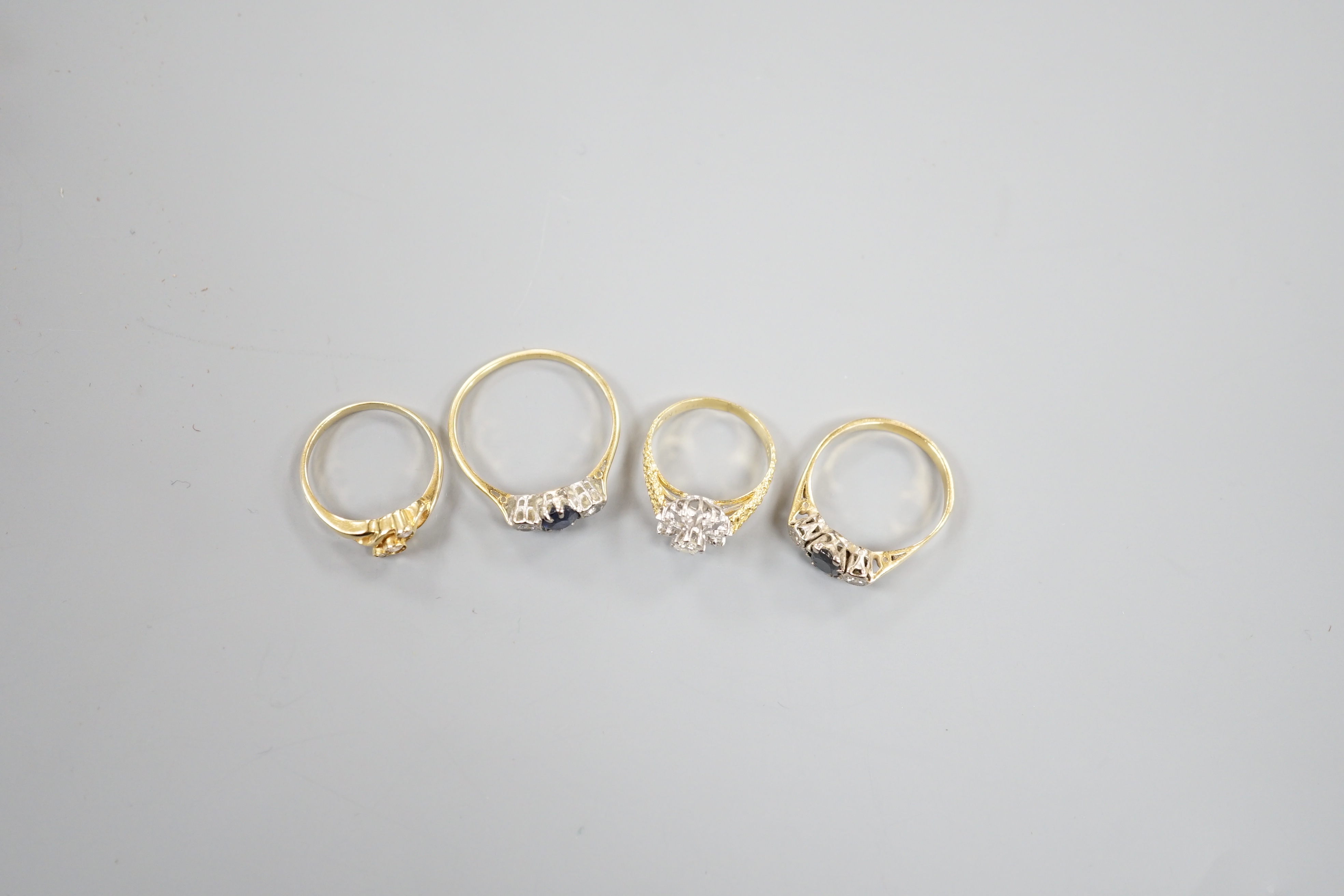 Two 18ct and gem set dress rings, including sapphire and diamond, gross 5.9 grams, a 585 crossover ring, gross 1.8 grams and a yellow metal, sapphire and diamond set ring, gross 3.1 grams.